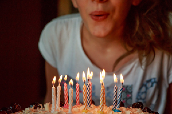 enfant soufflant ses bougies d'anniversaire
