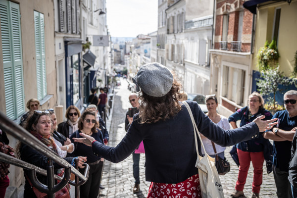 Anne-Sophie Guerrier de costas no topo da Rue Tholozé com vista para Paris, incluindo Les Invalides