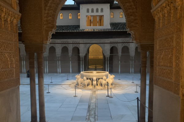 Fuente de los Leones en los Palacios Nazaríes de la Alhambra vistos a través de uno de sus arcos