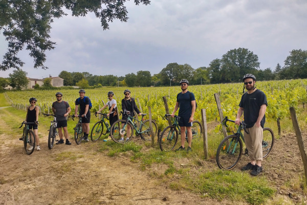 Foto de grupo en los viñedos durante la excursión en bicicleta de grava por Burdeos.