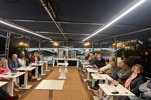 Cena en barco por Sevilla con menú degustación y vistas al río Guadalquivir.