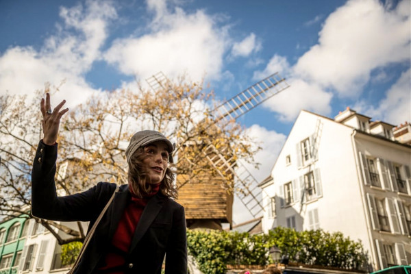 Anne-Sophie Guerrier zingend voor de windmolen van de voormalige balzaal Moulin de la Galette
