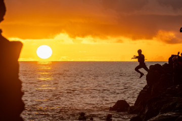 Jumping into the ocean at sunset