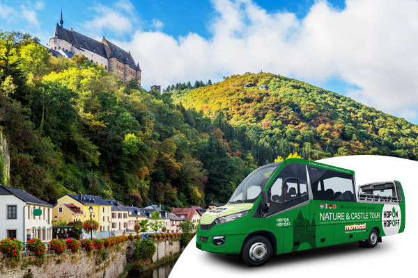 Convertible tourist bus with the city of Vianden in the background