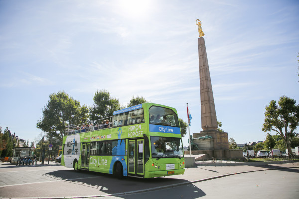 Hop On Hop Off Bus in front of the Gëlle Fra Monument at the Constitution Square