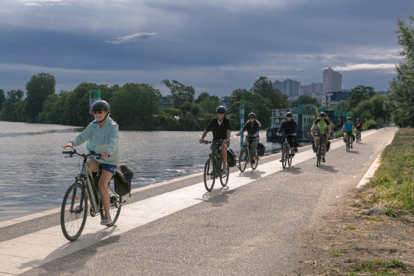 inaeri electric bike tour group rides along the river in paris on the way to versailles