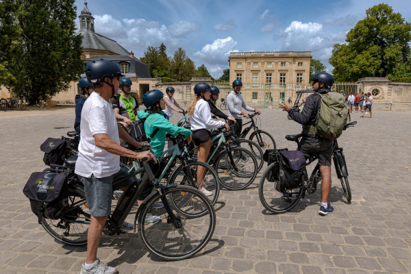 inaeri electric bike tour group stopped in front of little trianon in versailles palace domain