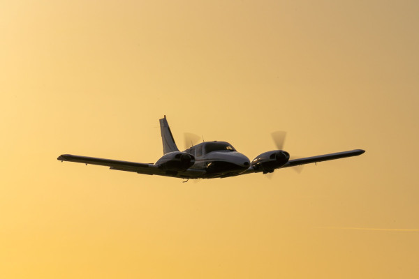 Twin engine aircraft in areas on golden yellow sky