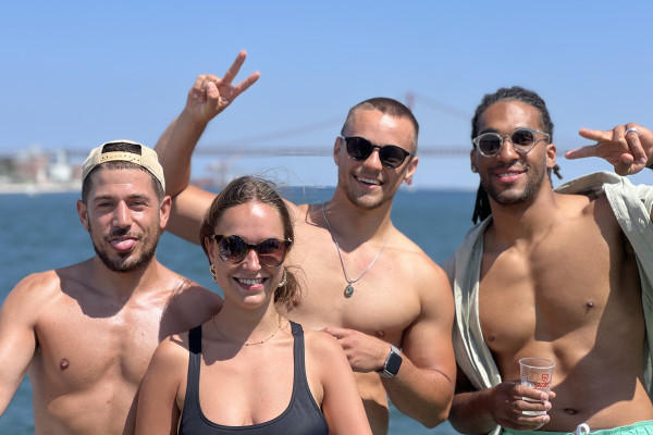 a group of 3 young good looking men and one women smiling and having fun on a boat party