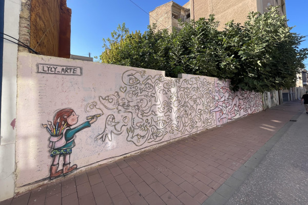 A hidden alley in El Cabanyal adorned with colorful murals and artistic flair.