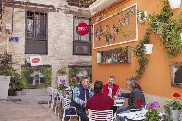 Group of people enjoying tapas and drinks on a charming terrace in Valencia’s old town