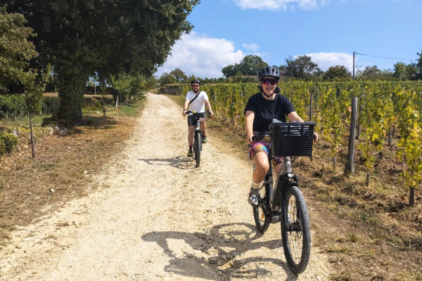 Cyclists enjoying premium electric bikes in the Bordeaux vineyards.