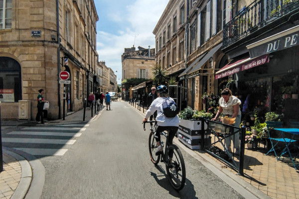 Exploring the Chartrons district on gravel bikes along Rue Notre-Dame.