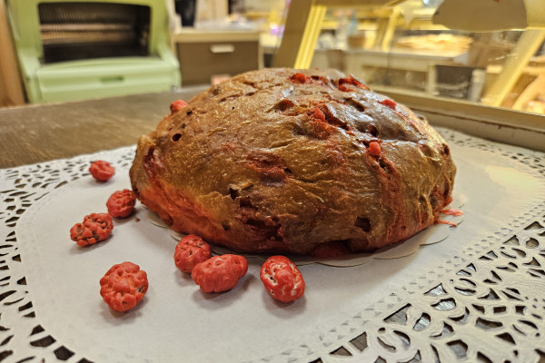 Tasting a brioche with pink praline, a Lyon specialty, during a food tour at Les Halles Paul Bocuse