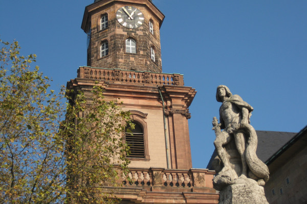 Turm der Dreifaltigkeitskirche und Drachentöter Siegfried auf dem Brunnen an der Hagenstraße