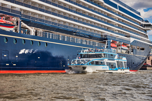 Fahrgastschiff fährt am Kreuzfahrtschiff vorbei