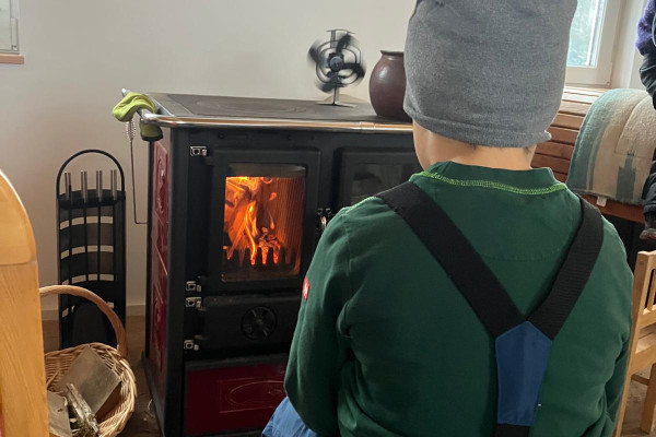 Kind vor dem Feuer im Ofen