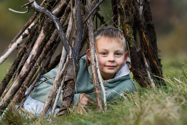Kind im gebauten Tipi