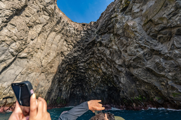 alt="Familie fotografiert die goldenen Meeresgrotten im Abendlicht"  