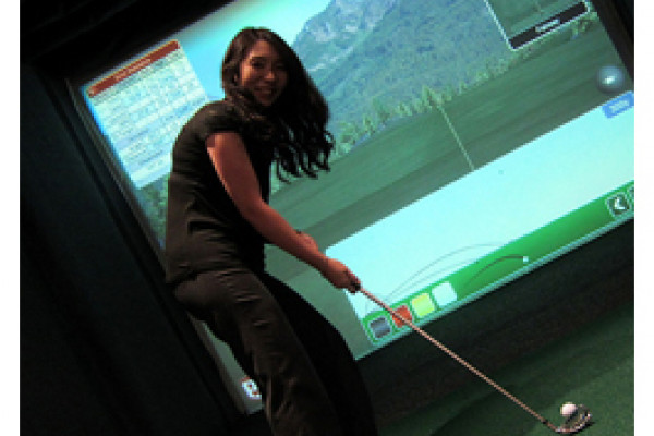 Golfspielerin im Simulator