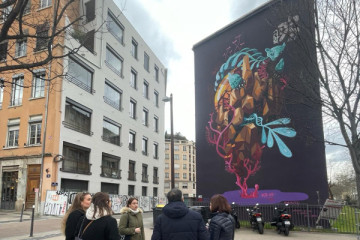 Le groupe est devant une grande peinture murale 