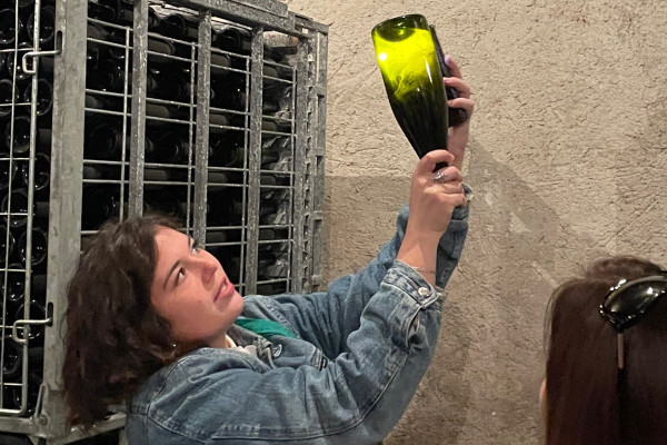 Héloïse montrant les levures dans une bouteille de champagne en vieillissement dans la cave.