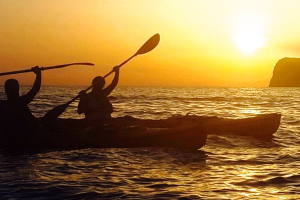 Kayak glissant sur les eaux turquoise de Sant Elm au coucher du soleil