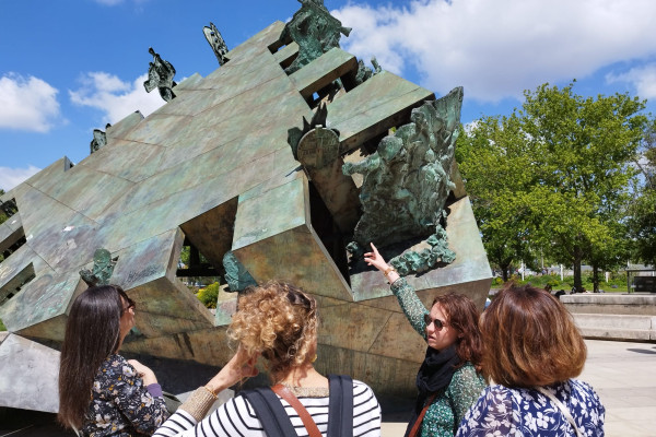 Un groupe et la guide devant la statue sur l'histoire lyonnaise place Louis Pradel