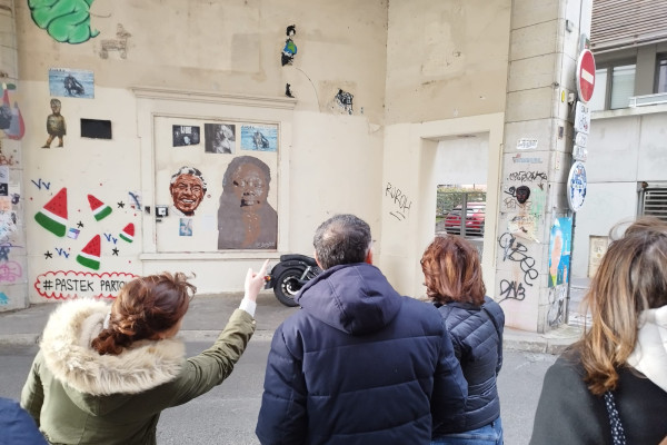 Le groupe regarde une rue remplis d'œuvres de différentes formes de Street Art