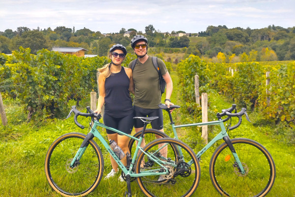 Petit groupe roulant en gravel entre les rangs de vigne.