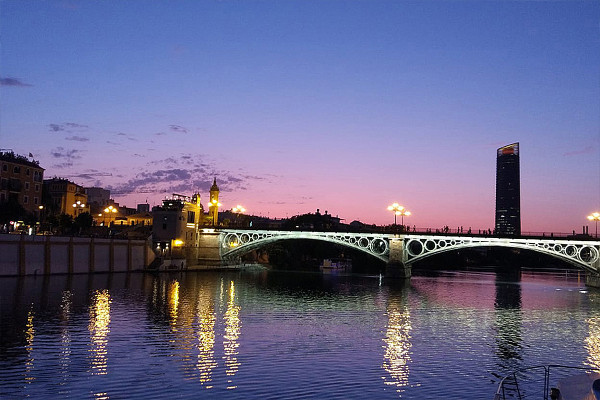 Vue nocturne du Puente de Triana pendant le dîner-croisière à Séville.