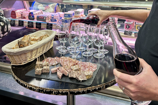 Dégustation de charcuteries locales avec verre de vin rouge Côté du Rhône Beaujolais lors d'un Food Tour aux Halles Paul Bocuse